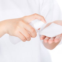 コットンに化粧水を含ませる手元、スキンケアの日常ケアの写真