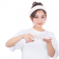 美容液をコットンに染み込ませる女性のスキンケアの写真