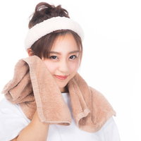 白いタオルで顔を拭うスキンケア中の女性のビューティーケアの写真