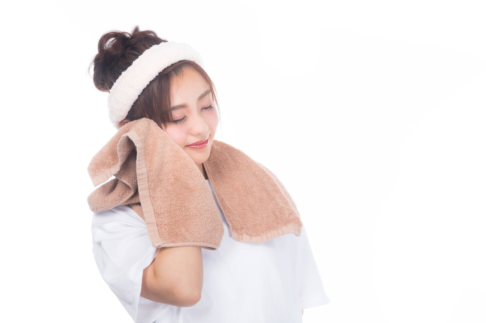 白いタオルで頬を覆い目を閉じている女性［モデル：河村友歌］