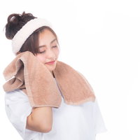 白いタオルで頬を覆う女性のスキンケア洗顔後の写真