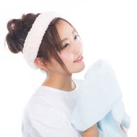 爽やかな朝にタオルを持って顔を洗う女性のスキンケアの写真