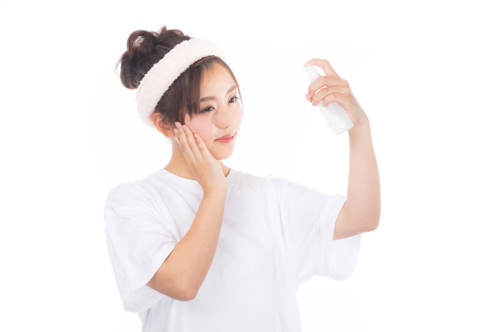 白い服を着た女性が顔に霧吹きでミストを吹きかけている［モデル：河村友歌］