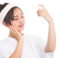 化粧水のミストで顔に潤いを与える女性のスキンケアの写真