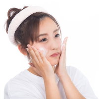 クレンジングの泡で洗顔中の女性のスキンケアの写真