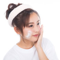 クレンジングの泡でメイク落とし、白いタオル姿の女子の写真