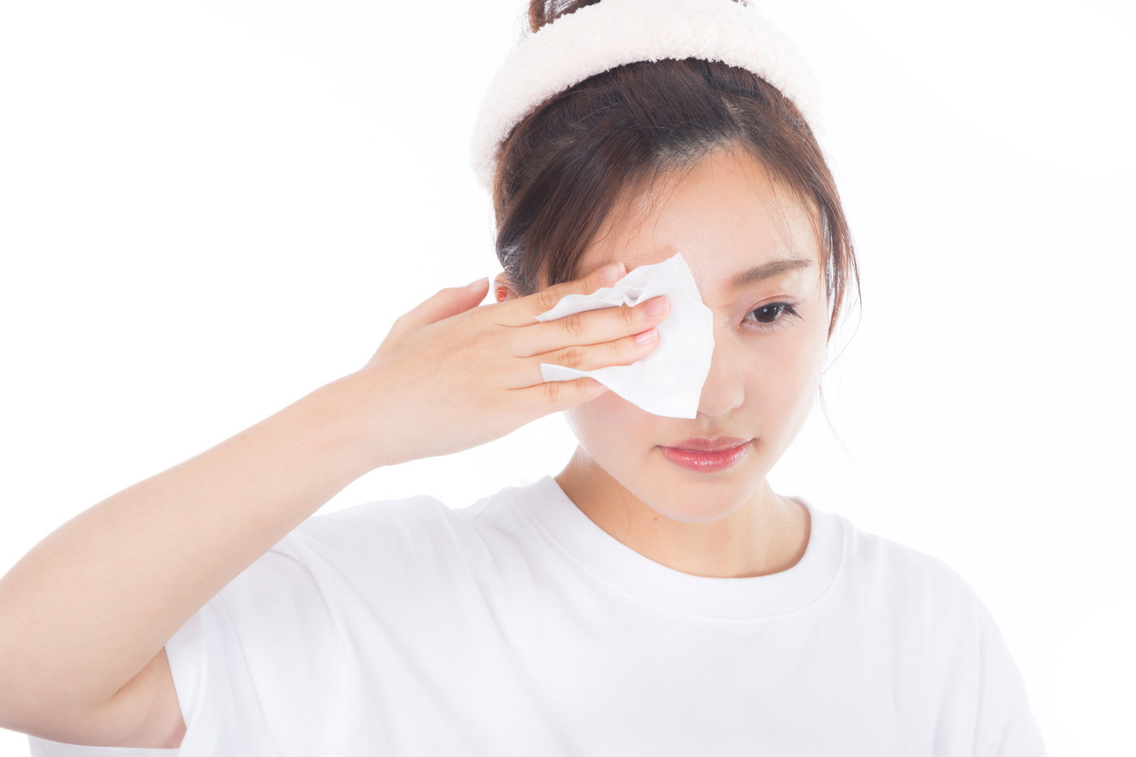 白いコットンを使って目元のメイクを落としている女性［モデル：河村友歌］