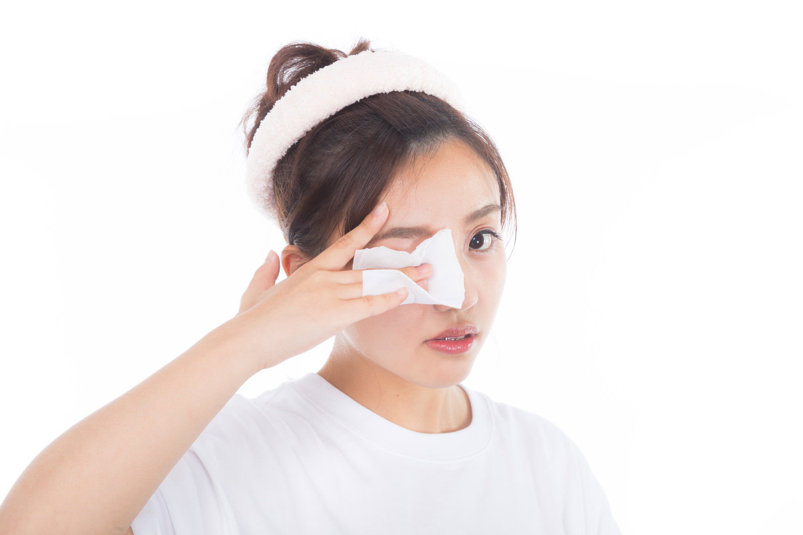 白いコットンで目元のメイクを落としている女性［モデル：河村友歌］