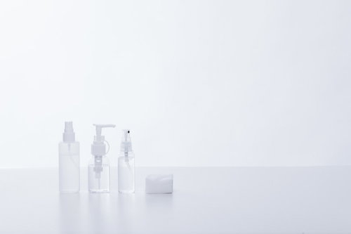 透明な化粧水の容器とコットン、スキンケア用品の製品撮影