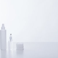 透明なボトル容器の化粧水とコットン、スキンケア用品の写真