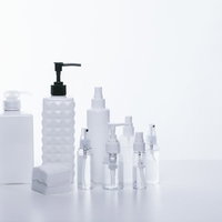 白い詰替えボトルに並ぶ化粧水とスキンケア容器の写真