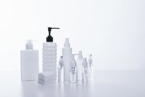 白い詰替えボトルに並ぶ化粧水とスキンケア容器