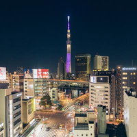 浅草吾妻橋から見た夜間のライトアップスカイツリーと街並みの写真