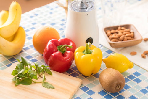 ジューサーとパプリカやキウイ、バジルなど新鮮な食材