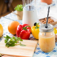 テーブルの上にあるスムージーと緑黄色野菜・果物の写真