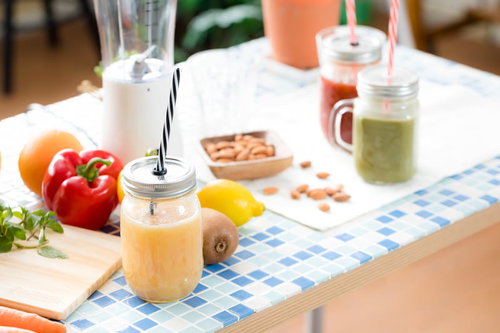 テーブルに並べたスムージーとフルーツ、ナッツのセット