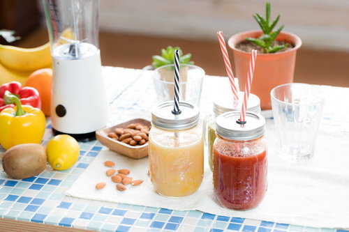 ナッツと新鮮なフルーツに囲まれたスムージーとレッドスムージー