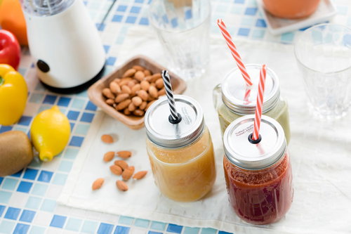 ストローが刺さったスムージー瓶とナッツ、レモンのテーブルセット