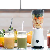 ジューサーに詰まったカット野菜と3種類のスムージーの写真