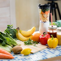 小松菜やレモン、パプリカなどの野菜と果物でスムージーを作るの写真