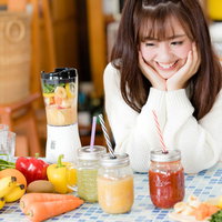 グリーンスムージーを作りすぎちゃった女性とたくさんのドリンクの写真