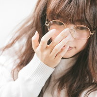 眼鏡をかけて考え込む女子のポートレートの写真