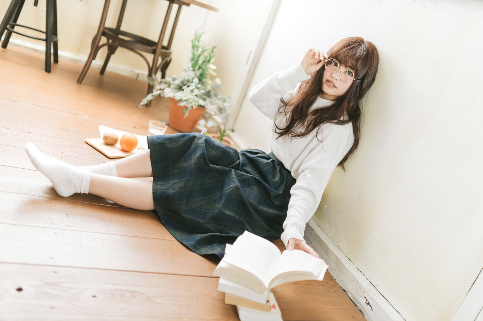 眼鏡をかけた女性が本を読んでいる様子［モデル：河村友歌］