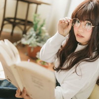 眼鏡をかけて本を読む文系女子のポートレートの写真