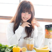 フルーツのスムージーを作ってご満悦の笑顔の女性の写真