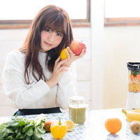 リンゴとレモンを持って微笑むスムージー女子の写真