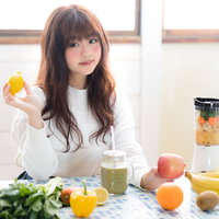 レモンを持ったスムージー女子とフルーツジューサーの写真