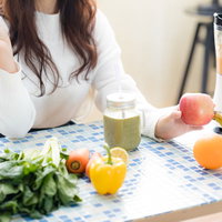 ジューサーで作るグリーンスムージーと新鮮な林檎の写真