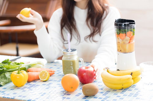 朝食テーブルに並ぶりんごと果物のグリーンスムージー