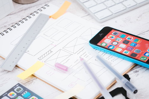 ワイヤーフレームが書かれたノートとスマートフォン