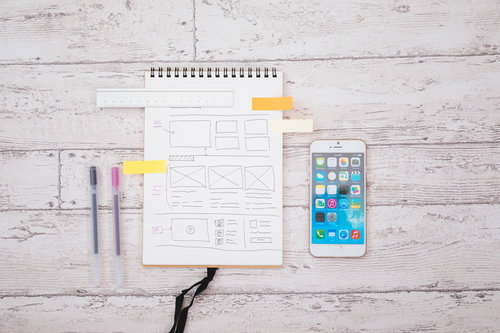 スマホとワイヤーフレームが書かれたノートでディレクション