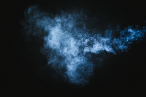 暗い背景に立ち上る薄く吐き出された白煙のスモーク
