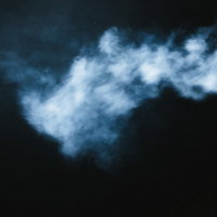 暗闇に立ち上る白い副流煙の写真