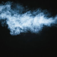 黒い背景に白くもくもくする煙の立ち上る様子の写真
