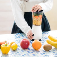 新鮮な果物と野菜をジューサーにかける様子の写真
