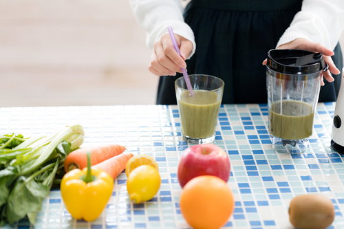 グリーンスムージーを入れたグラスと新鮮な野菜