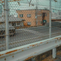 ガードレールと通過する車両の屋根の写真