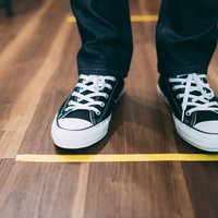 お並びになる時は黄色い線まで離れてください～ソーシャルディスタンスの啓発の写真