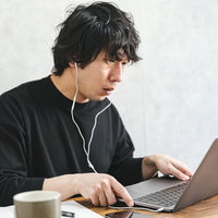 自身の書籍に酷似した表紙を見つけて驚く男性エンジニアの写真