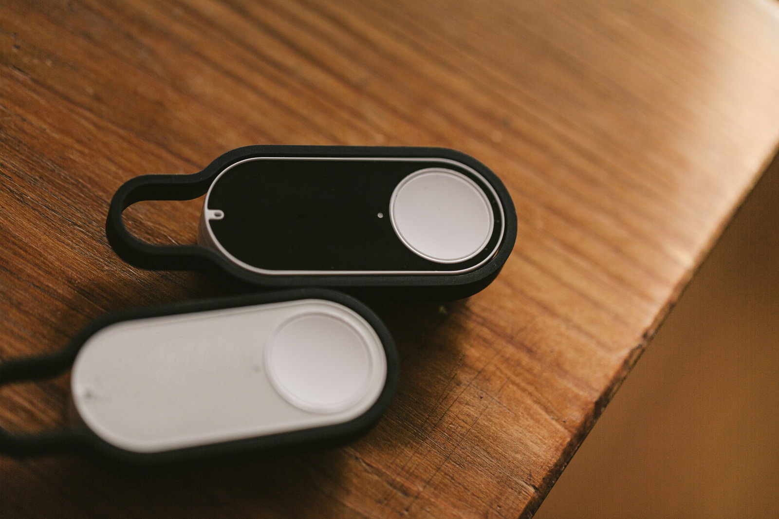 木製テーブルの上の黒と白のダッシュボタン2個