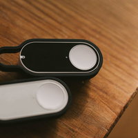 木のテーブルに置かれた黒と白のダッシュボタンの写真