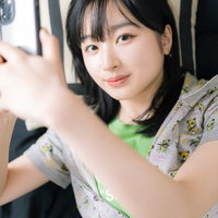 寝転びながらスマホを操作するスマホ女子のリラックス風景の写真
