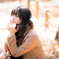 寒さでマフラーをギュッと握りしめる女性のポートレートの写真