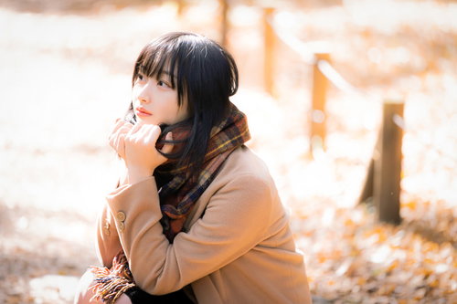 寒さでマフラーをギュッと握りしめる女性のポートレート