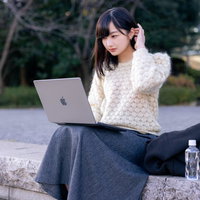 気晴らしに屋外で作業するエンジニア女性とノートパソコンの写真