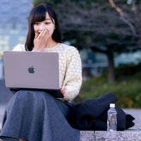 口元に手を添えて驚くリモートワーク中の女性がボイチャで反応の写真